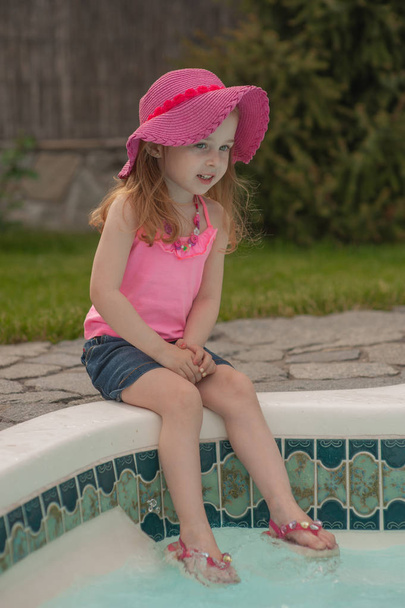 Παιδί κορίτσι αναπαύεται κοντά στην πισίνα. - Φωτογραφία, εικόνα