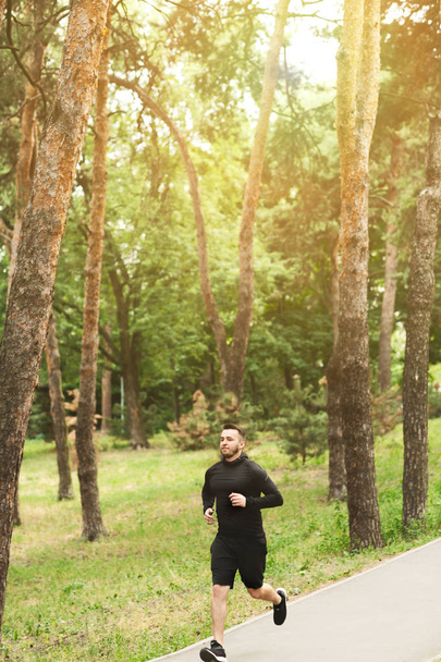 Poranny trening. Mężczyzna biegacz jogging w parku na dworze - Zdjęcie, obraz