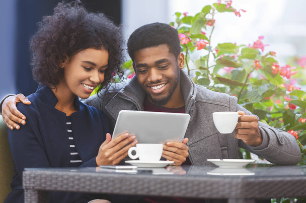 Joyeux jeune couple africain faisant du shopping en ligne avec tablette
 - Photo, image