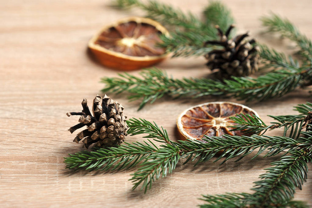 Christmas composition. Spruce branch with cones and slices of dry orange. Light background. Close-up. Macro shooting. - Foto, immagini