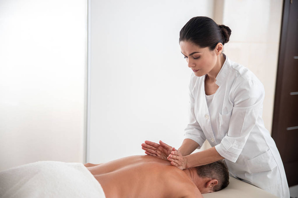 Professional massage therapist is doing shoulder massage - Fotó, kép