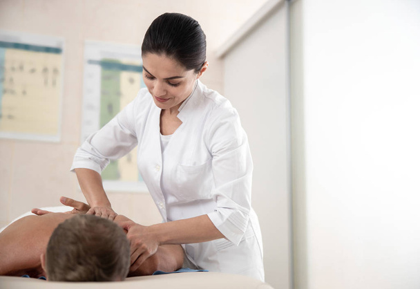 Pretty female doctor is doing massage in hospital - Φωτογραφία, εικόνα