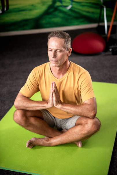 Дорослий чоловік в медитації в положенні лотоса
 - Фото, зображення
