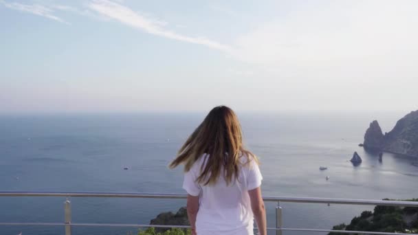 Young adult woman looking at sea view - Materiaali, video