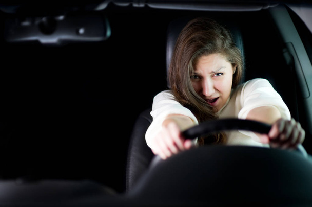 girl is afraid holding the steering wheel. copy space - Фото, зображення
