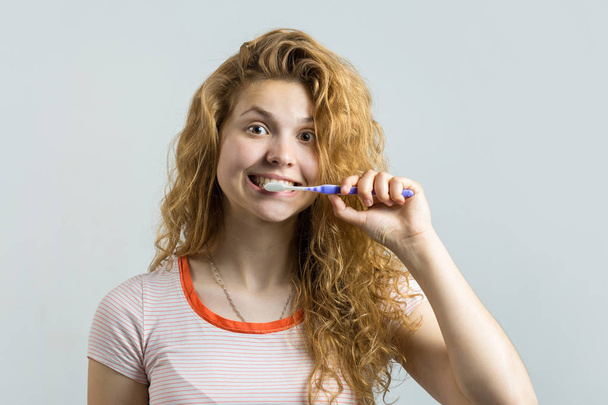 mladá žena čištění zubů s kartáčkem - Fotografie, Obrázek