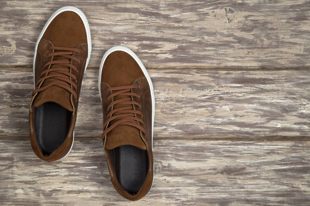 Coppia di scarpe in pelle marrone con spazio copia su sfondo in legno
 - Foto, immagini