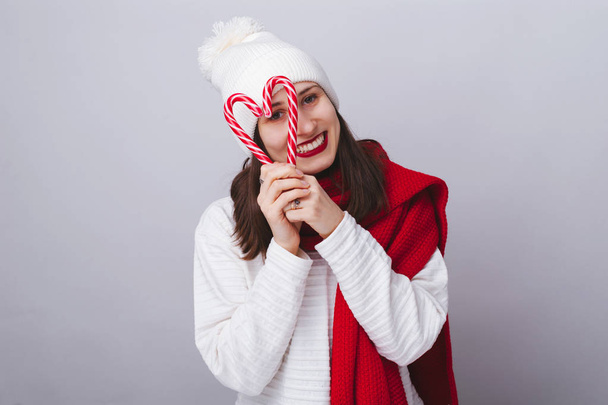 Mujer joven alegre, con sombrero blanco y suéter, bufanda roja, un
 - Foto, Imagen