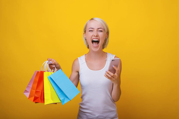 aufgeregte blonde Frau, schreit nach einem großen Einkauf, steht o - Foto, Bild