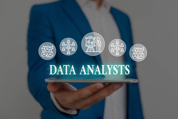 Text sign showing Data Analysts. Conceptual photo Programmer Design and Create Report Identifies patterns Male human wear formal work suit presenting presentation using smart device. - Photo, Image