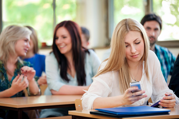 Студент с телефоном в классе
 - Фото, изображение