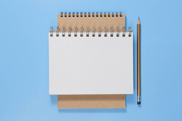 vista dall'alto di notebook aperto con matita su sfondo blu
 - Foto, immagini