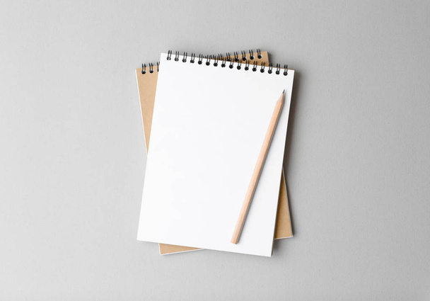 bovenaanzicht van een open notitieboekje met potlood op een grijze achtergrond - Foto, afbeelding