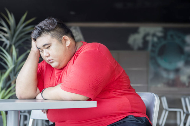 Overweight man looks desperate in the restaurant - Zdjęcie, obraz