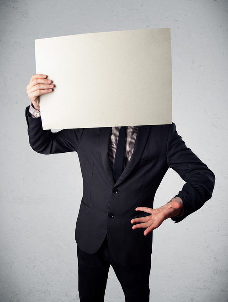 Businessman holding in front of his head a paper with copy space - Foto, Imagem
