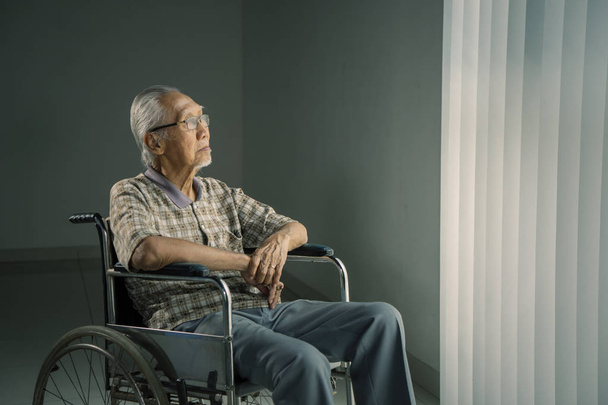 Senior man thinking something in a wheelchair - Zdjęcie, obraz