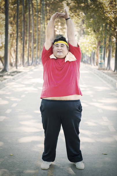 Young fat man looks tired after exercises on studio - Foto, Imagem
