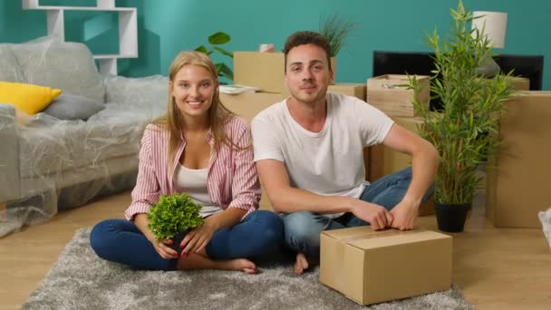 Retrato de um jovem casal em um novo apartamento sentado no chão
 - Filmagem, Vídeo