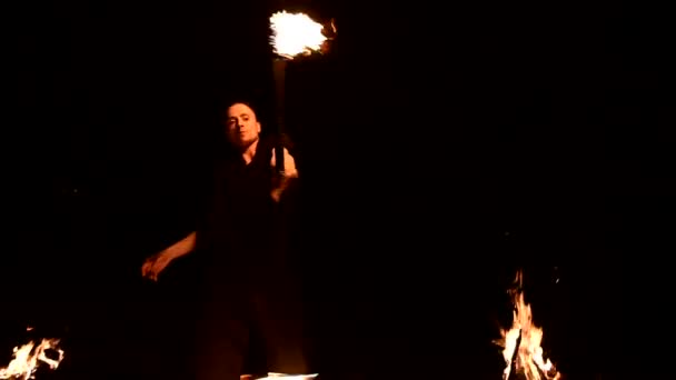 Movimento lento de um jovem de calças pretas na escuridão total mostra uma representação de uma tocha rotativa em chamas. Meditação em movimento. Calma e inabalável. Trabalhar com fogo. Tecla baixa
 - Filmagem, Vídeo