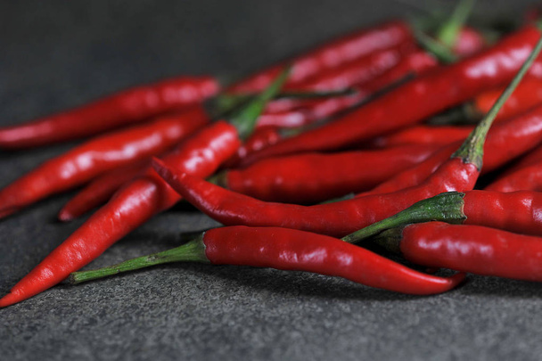 Hot red chili peppers on a dark surface. Pepper takes up most of the frame. Close-up. - Foto, imagen