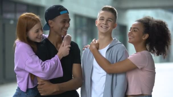 Knuffelen tiener koppels glimlachen om de camera, eerste relatie, ware vriendschap - Video