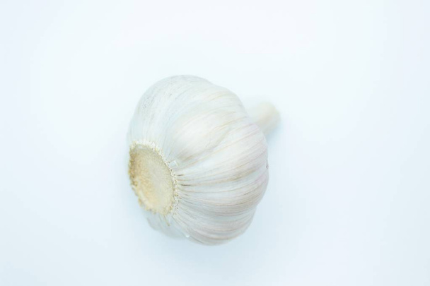 The head of garlic is located on a white background - Valokuva, kuva