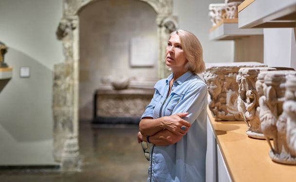 visitante femenina de mediana edad en el museo de arte o arqueología
. - Foto, imagen