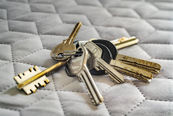 Old worn keys on a grey cloth - Photo, Image