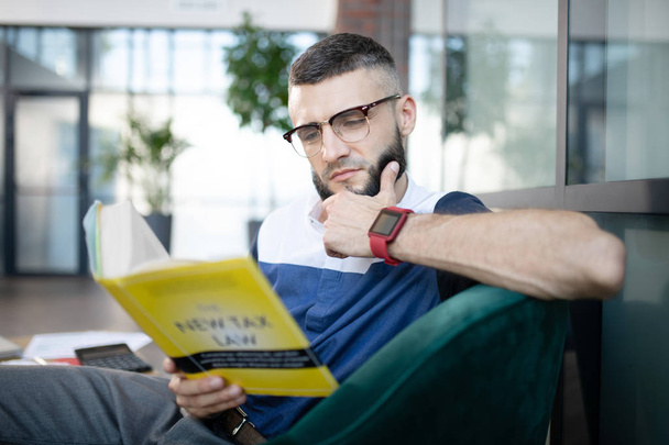 Businessman wearing smart watch feeling busy while reading - 写真・画像