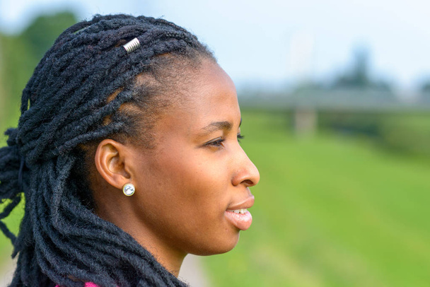 Profil de femme africaine réfléchie portant des tresses
 - Photo, image