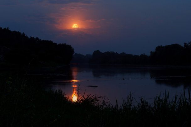 La luna llena sube sobre el río
 - Foto, Imagen