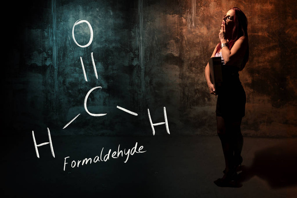 Sexy fille ou secrétaire ou étudiante présentant la formule chimique dessinée à la main de formaldéhyde
 - Photo, image