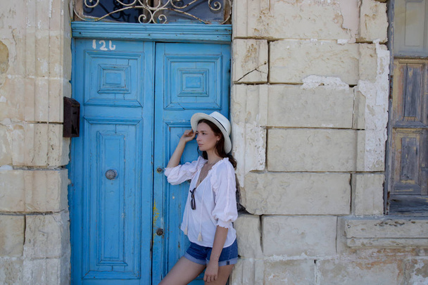 A casual fashion portrait of a young tourist woman in a summer outfit on the street - Photo, Image