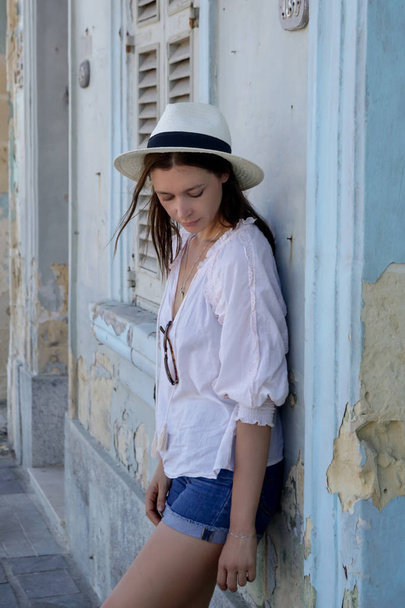 ein lässiges Modeporträt einer jungen Touristin im Sommeroutfit auf der Straße - Foto, Bild