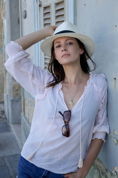 Een casual mode portret van een jonge toeristische vrouw in een zomer outfit op straat - Foto, afbeelding