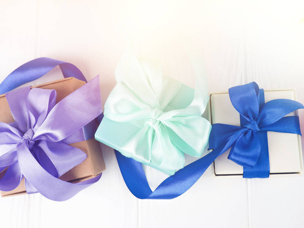 μπλε κουτιά με μωβ τόξα, Χριστουγεννιάτικα δώρα σε λευκή πλάτη - Φωτογραφία, εικόνα