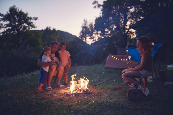 Father with children making a camping fire in the backyard. - Zdjęcie, obraz
