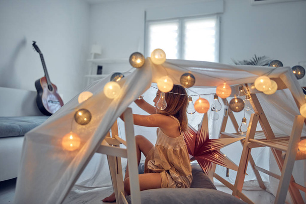 Little girl playing and making a house tent in the room. - Photo, Image