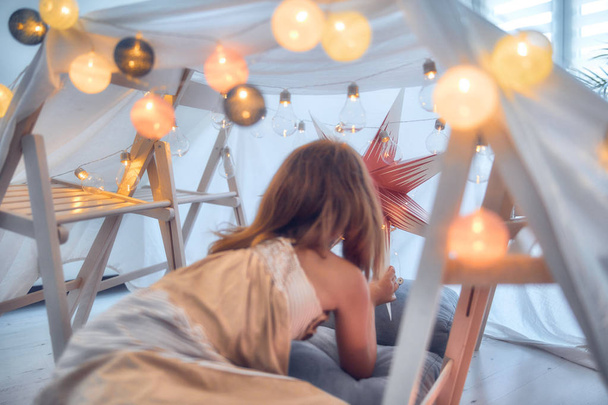 Meisje spelen en het maken van een huis tent in de kamer. - Foto, afbeelding