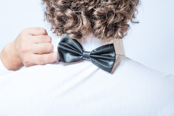 Bow tie on the back side. Strange or fun concept. Back view of an elegant young fashion man in tuxedo , toned image - Foto, Imagen