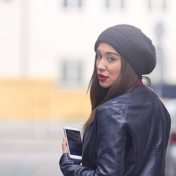 Молодая женщина в шляпе и мобильнике на улице
. - Фото, изображение