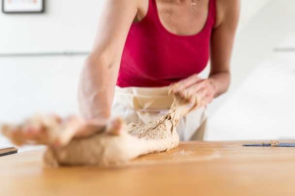 Nő térdelő tészta a konyhában - Fotó, kép