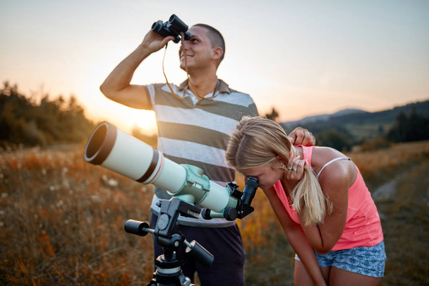 Отец и дочь наблюдают небо с помощью телескопа
. - Фото, изображение