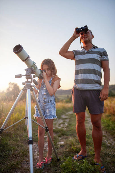 Apa és lánya teleszkóppal figyelik az eget.. - Fotó, kép