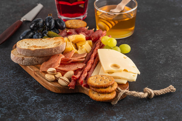 Italian food ingredients ham, salami, parmesan, olives, honey, bread. - Photo, image