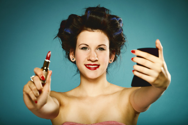girl in curlers styling hair applying make up - Foto, Imagen
