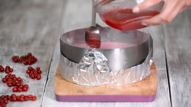 Confiseur versant de la gelée rouge sur un gâteau en mousse. Concept de cuisine. Aliments sucrés
. - Séquence, vidéo