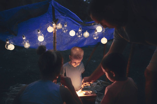 Father with children playing under their backyard tent. - Photo, Image