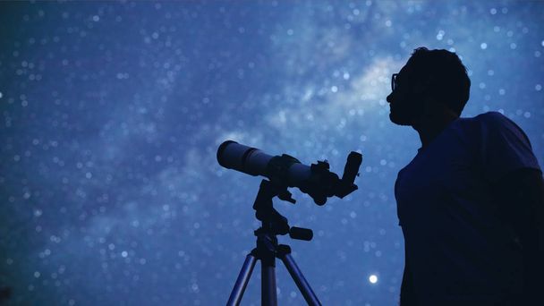 Astronom mit einem Teleskop, das Sterne und Mond beobachtet. mein a - Foto, Bild