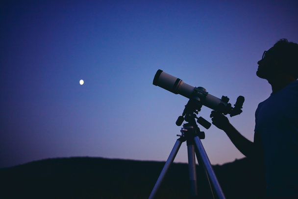 Астроном с телескопом наблюдает за звездами и Луной. Мой а
 - Фото, изображение